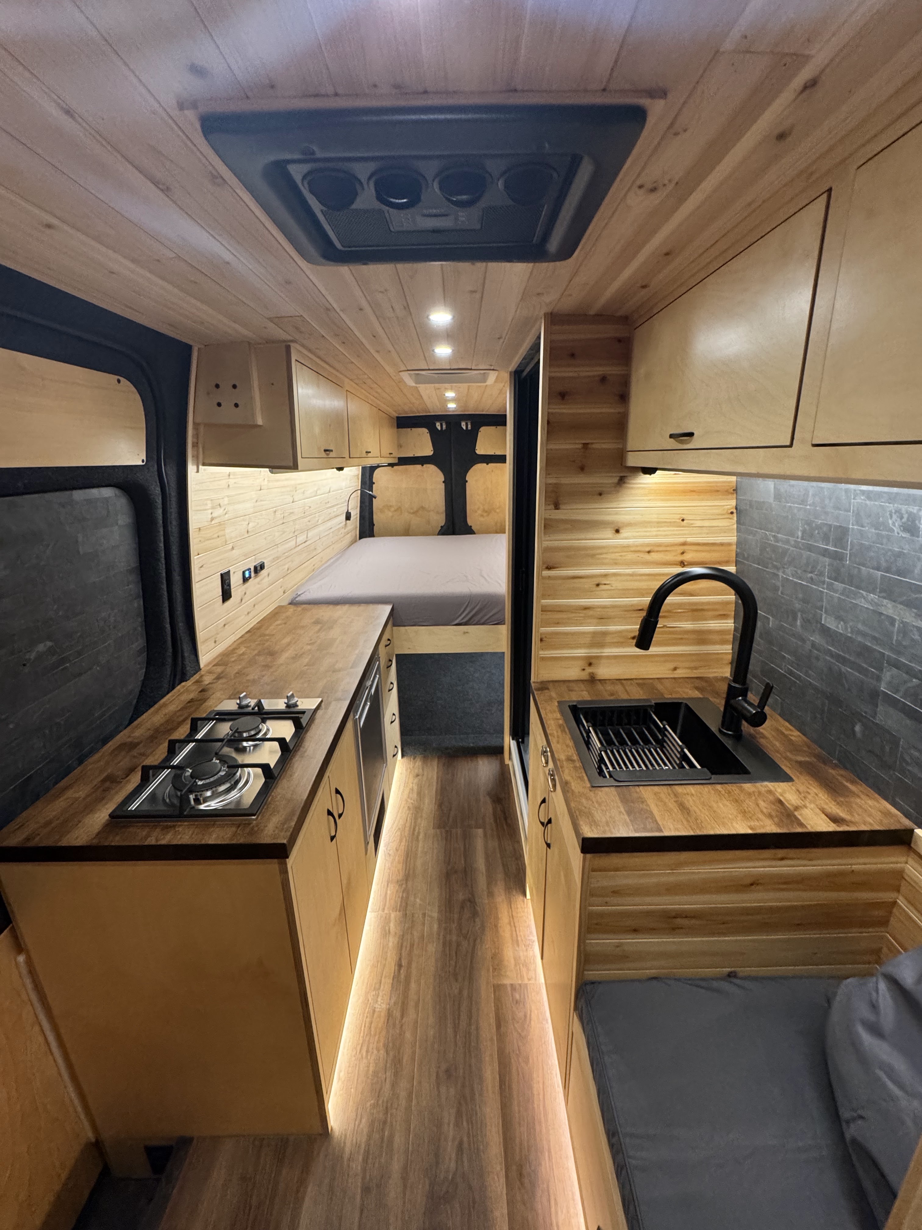 Van interior, full kitchen and bed view